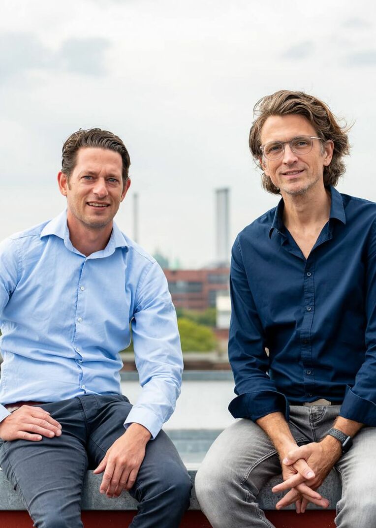 Geschäftsführer Ben Künkler und Eric Ovaska sitzen auf dem Dach der VALID Digitalagentur über Berlin.