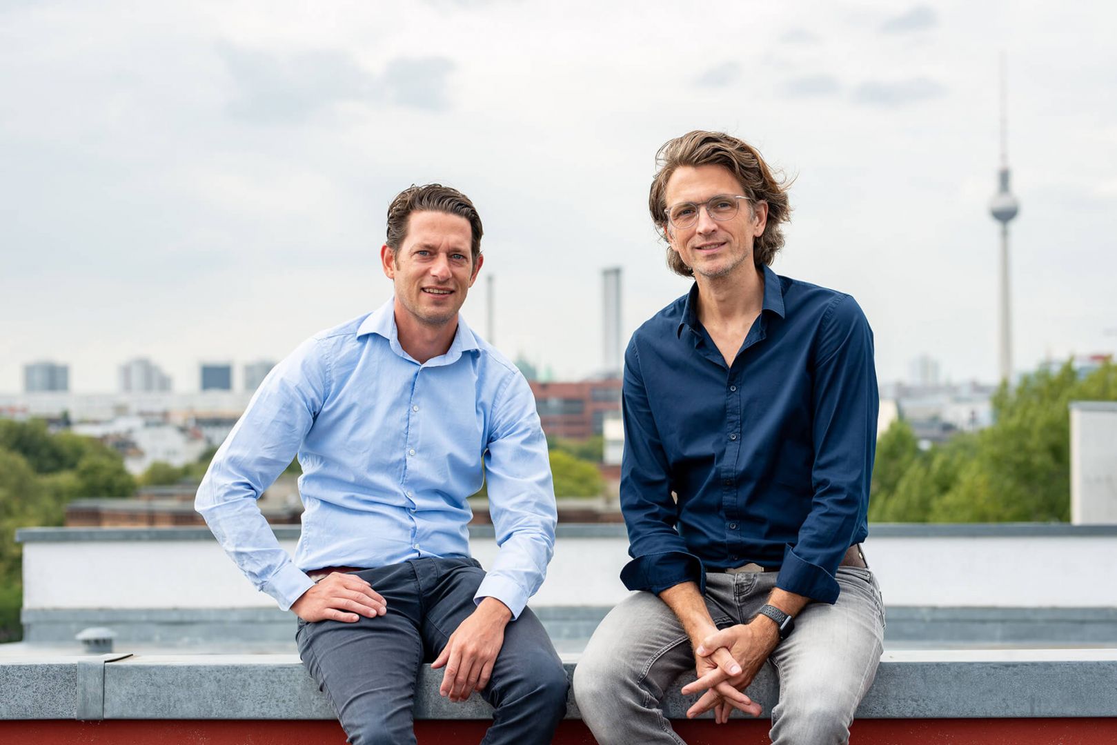 Geschäftsführer Ben Künkler und Eric Ovaska sitzen auf dem Dach der VALID Digitalagentur über Berlin.
