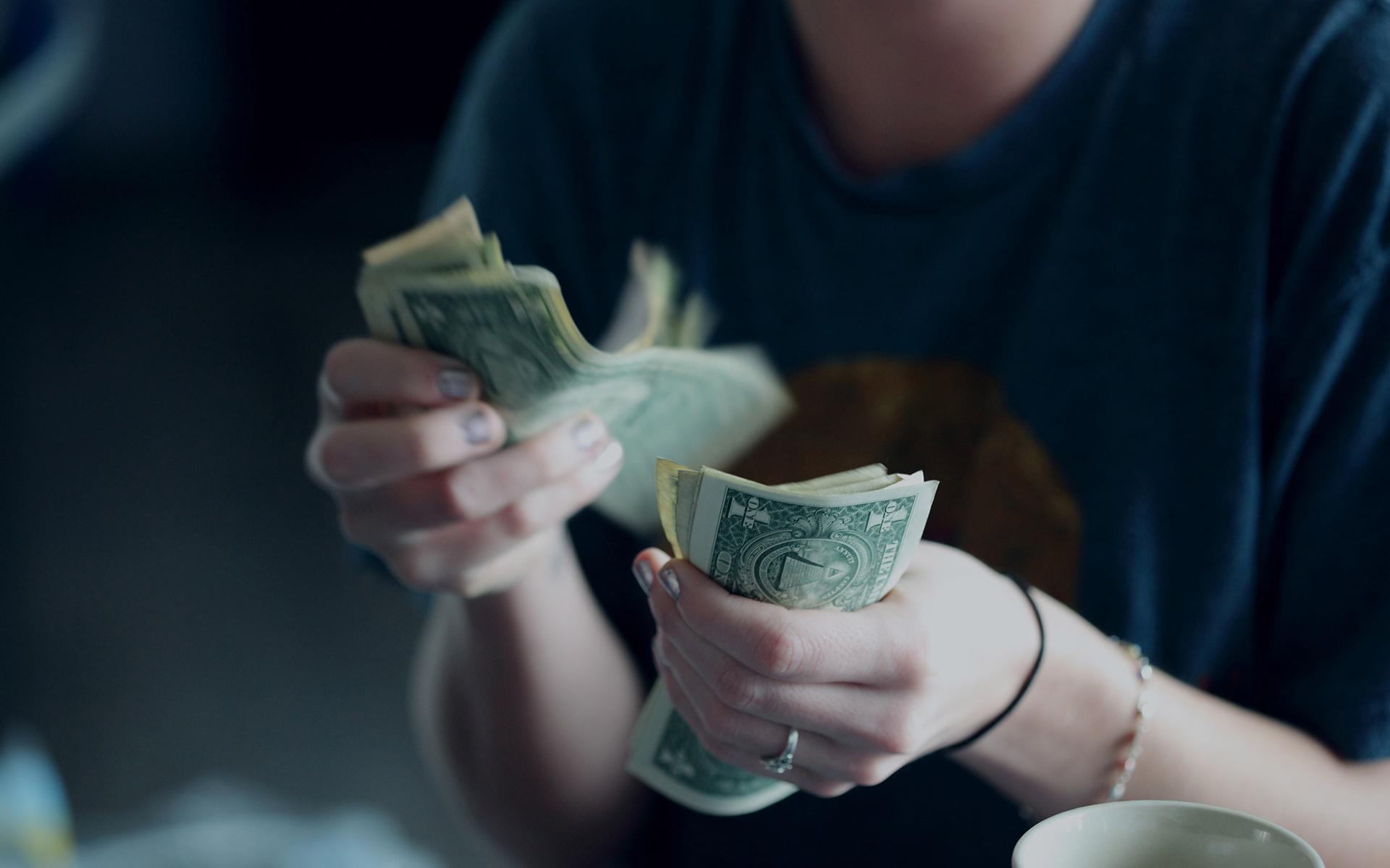 Person hält Dollarscheine in der Hand.