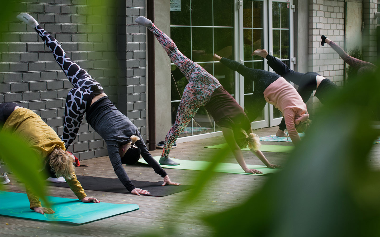 Personen machen Yoga auf einer Terrasse.